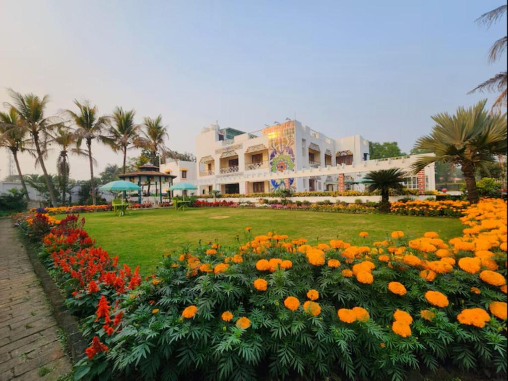 a field of flowers in front of a building at Lukochurri in Shānti Niketan