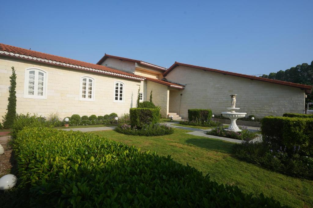 a house with a garden and a fountain in the yard at La Villa des Chien in Ban Nong Chap Tao