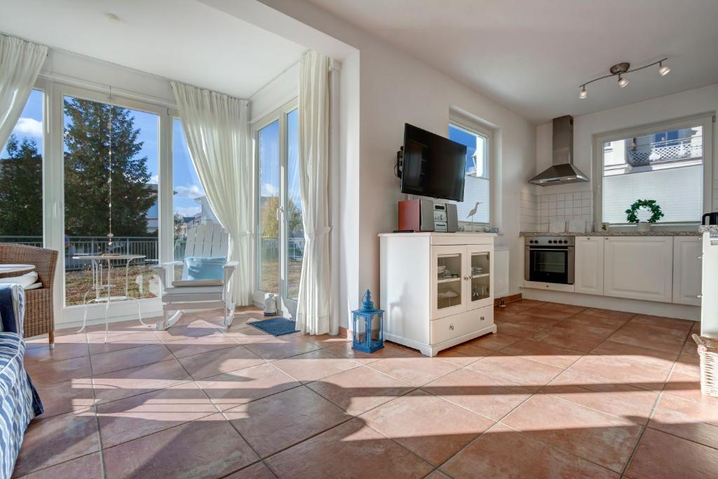 a living room with large windows and a kitchen at Haus Meerblick - 14 in Ahlbeck