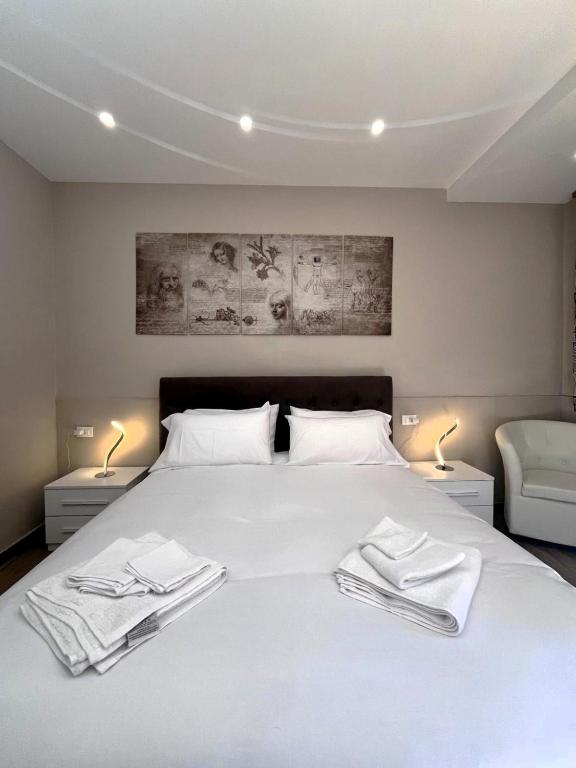 a bedroom with a white bed with two white towels on it at Rifugio AL in Randazzo