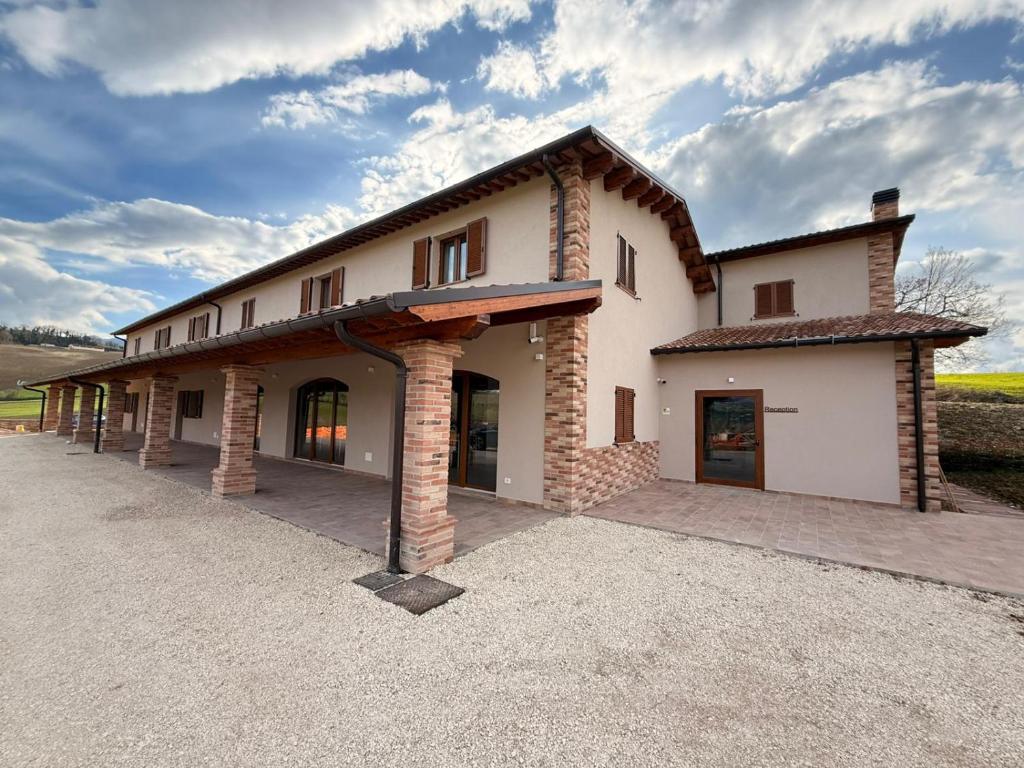 a large white building with a roof at Palombarone Resort in Matelica
