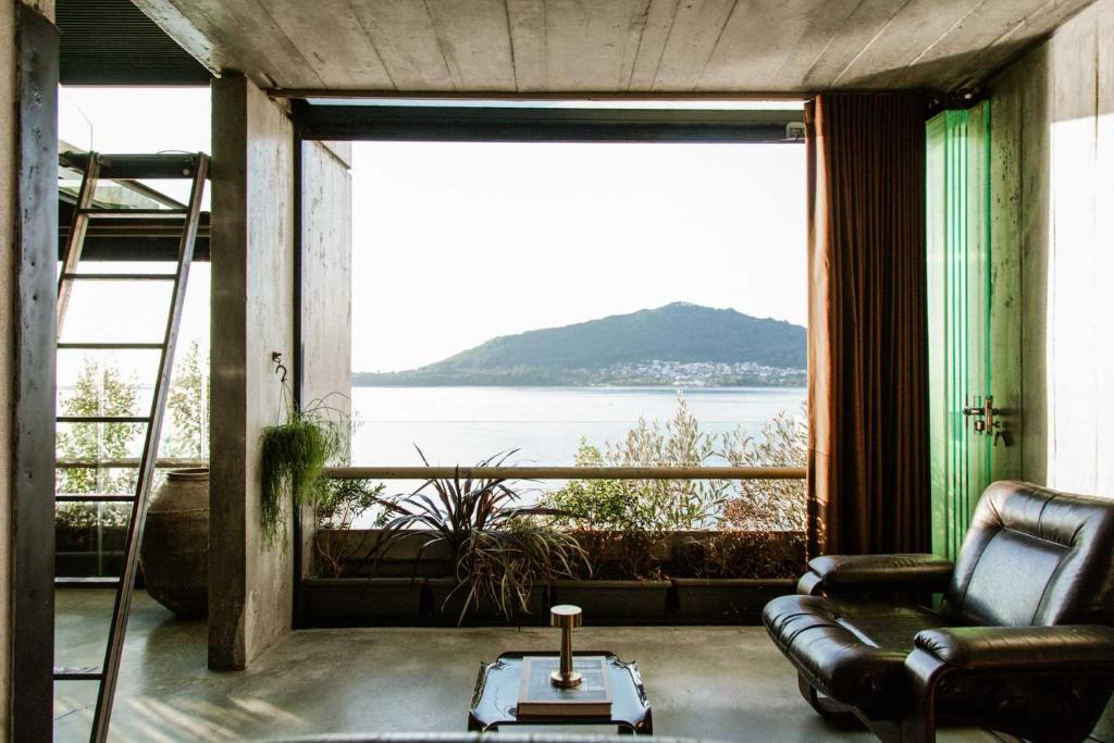 a living room with a couch and a large window at Luxury Waterfront Loft with Panoramic Views in Caminha