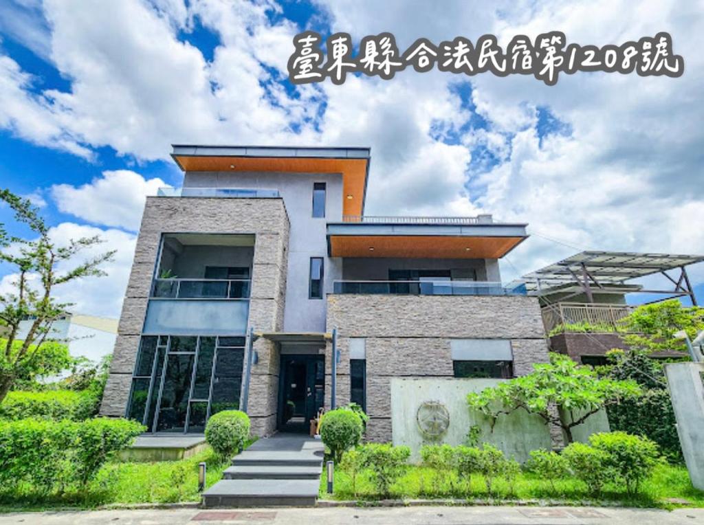 a house with an asian writing on the side of it at 茶田關舍民宿Tea Paddy B&B-臺東縣民宿1208號 in Guanshan