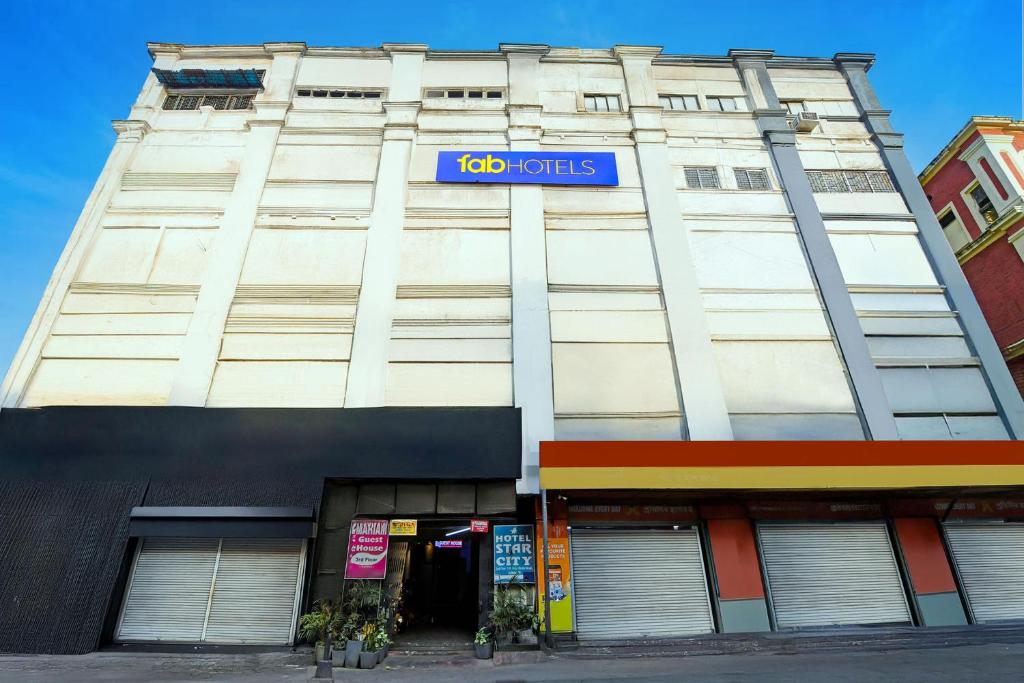 a building with a blue sign on the side of it at FabHotel Demattrie Budget in Kolkata