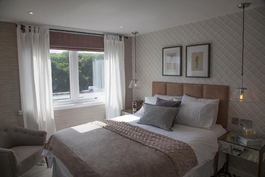 a bedroom with a large bed and a window at Albero Apartment in Eyemouth