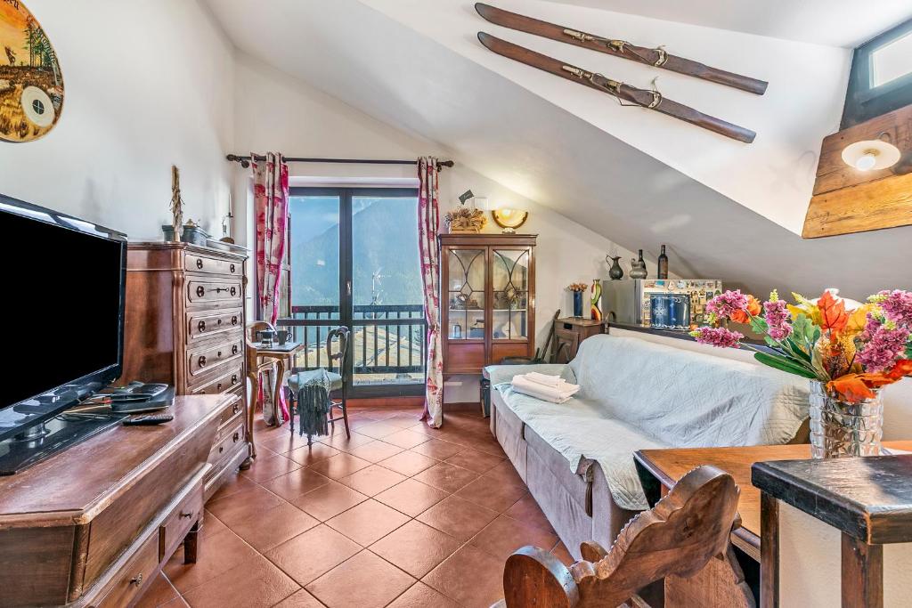 a living room with a couch and a tv at Champlas Suite - Happy Rentals in Sestriere
