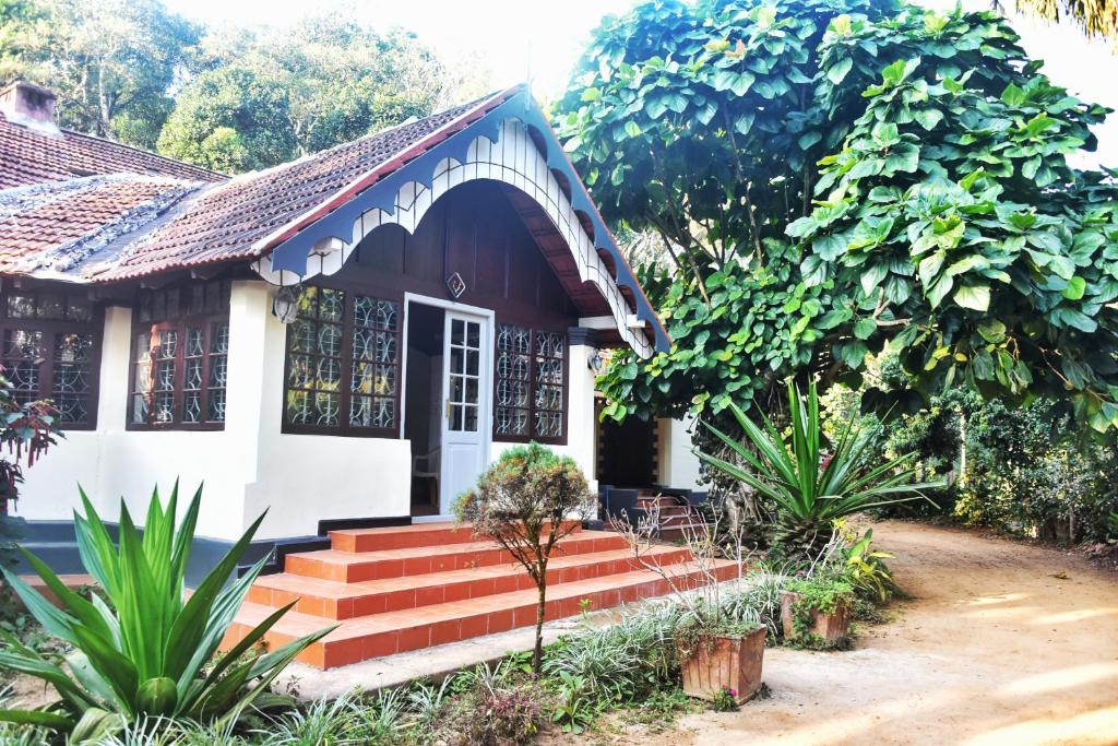 a house with a staircase leading to the front door at Colonial canopy in Suntikoppa