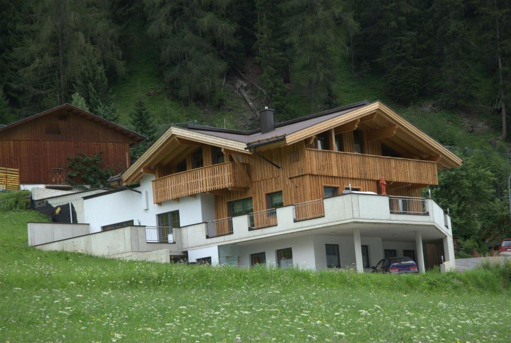 a house with a wooden roof on top of a hill at Apart Jehle in Sankt Anton am Arlberg