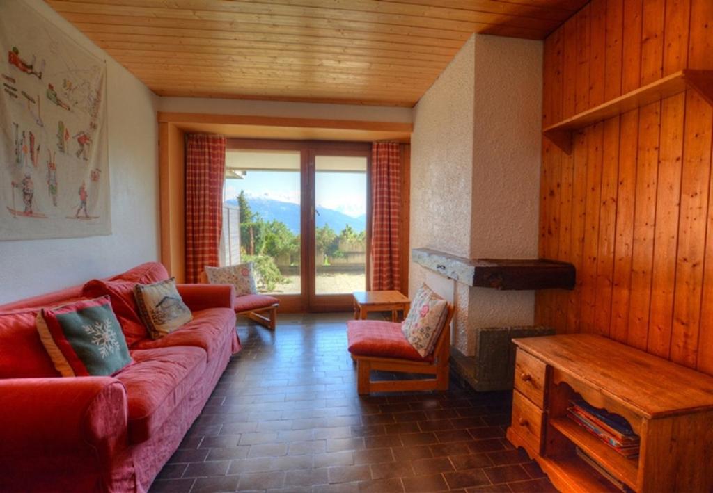a living room with a red couch and a fireplace at Antares 006 au centre a Anzere in Anzère