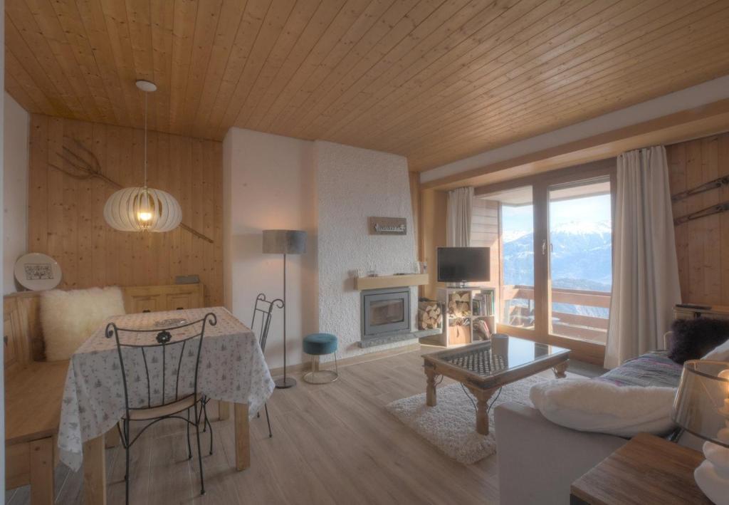 a living room with a table and a living room with a view at Antares 402 au centre a Anzere in Anzère