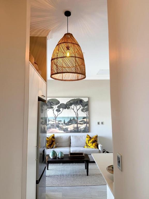 a living room with a couch and a hanging light at Palm Springs in Struisbaai