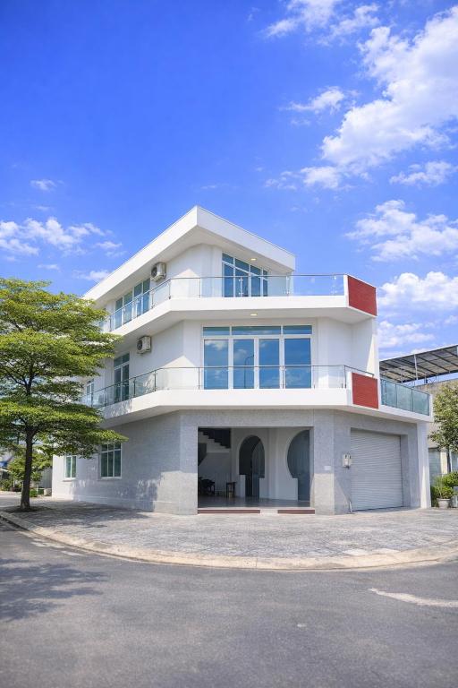 a large white building with a tree in front of it at Love's Hotel in Nhơn Trạch