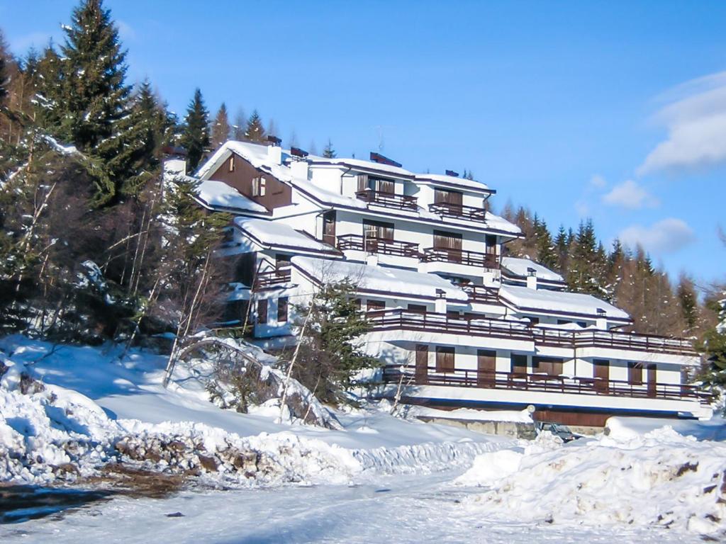 a large building on top of a snow covered mountain at Residence Stefania in Teglio