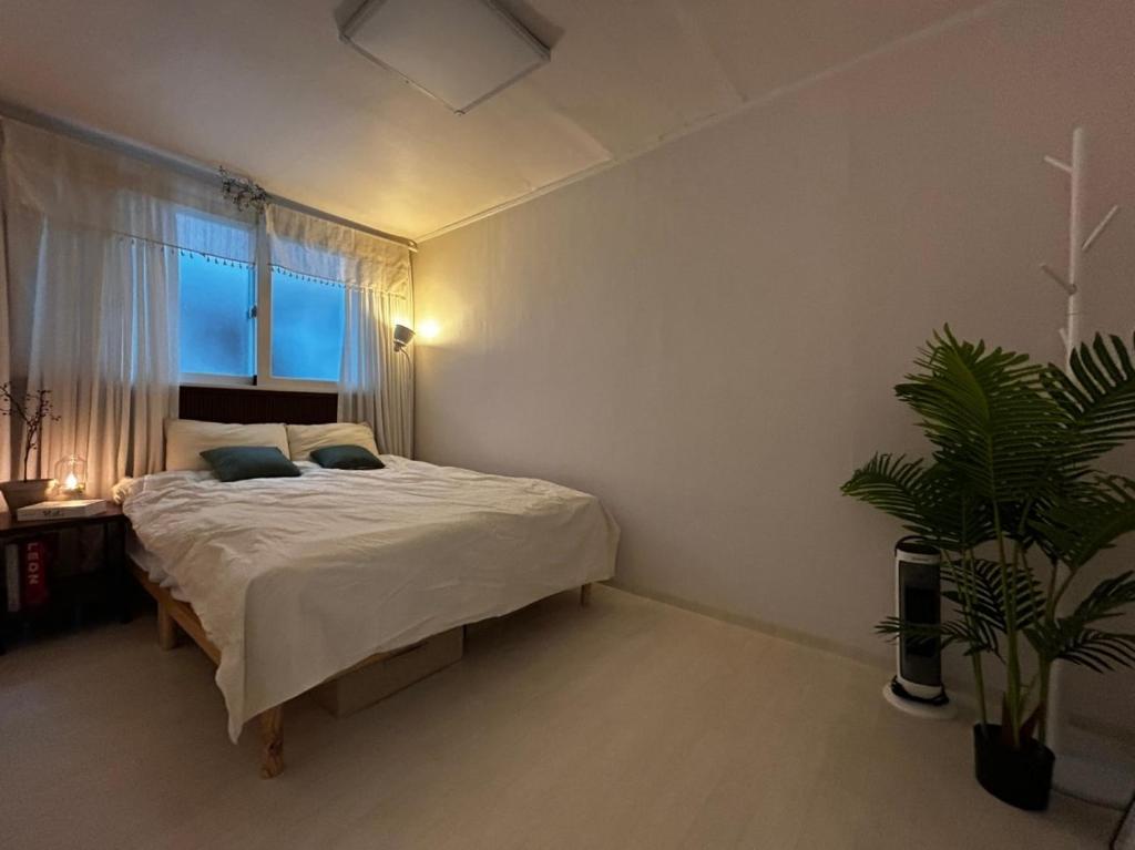 a bedroom with a bed and a potted plant at Hill-house in Samgong