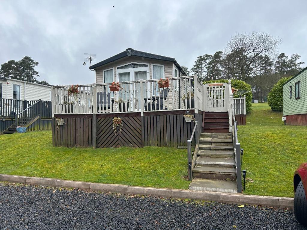 a house with a deck and stairs in a yard at 26 Golf View in Jedburgh