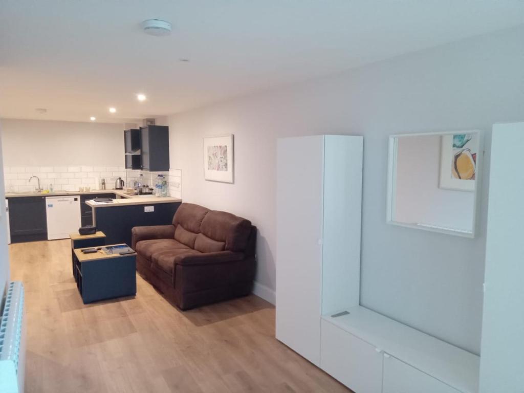 a living room with a couch and a kitchen at Village Centre Haven in Clifden