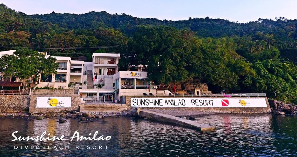 a bridge over a body of water with houses at Sunshine Anilao Dive and Beach Resort in Batangas City