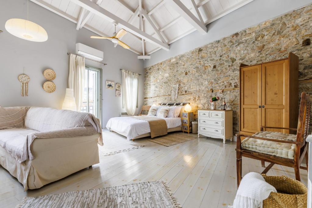 a bedroom with a bed and a stone wall at La Casa Del Limon - Sea Views & Walkable Location in Skopelos Town