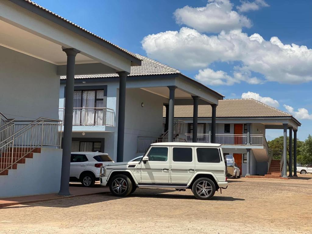 a white jeep parked in front of a house at Nandi Gosa Apartments in Mahikeng