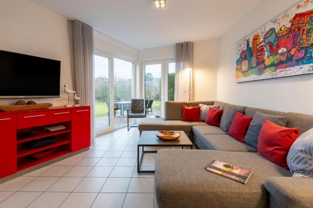 a living room with a couch and a flat screen tv at Haus Stranddüne in Borkum