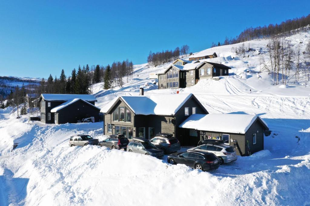 a house with cars parked in the snow at Intersporthytta Sogndal in Sogndal