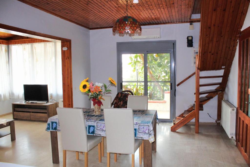 a dining room with a table and chairs and a television at Komninos' Traditional House in Artemida