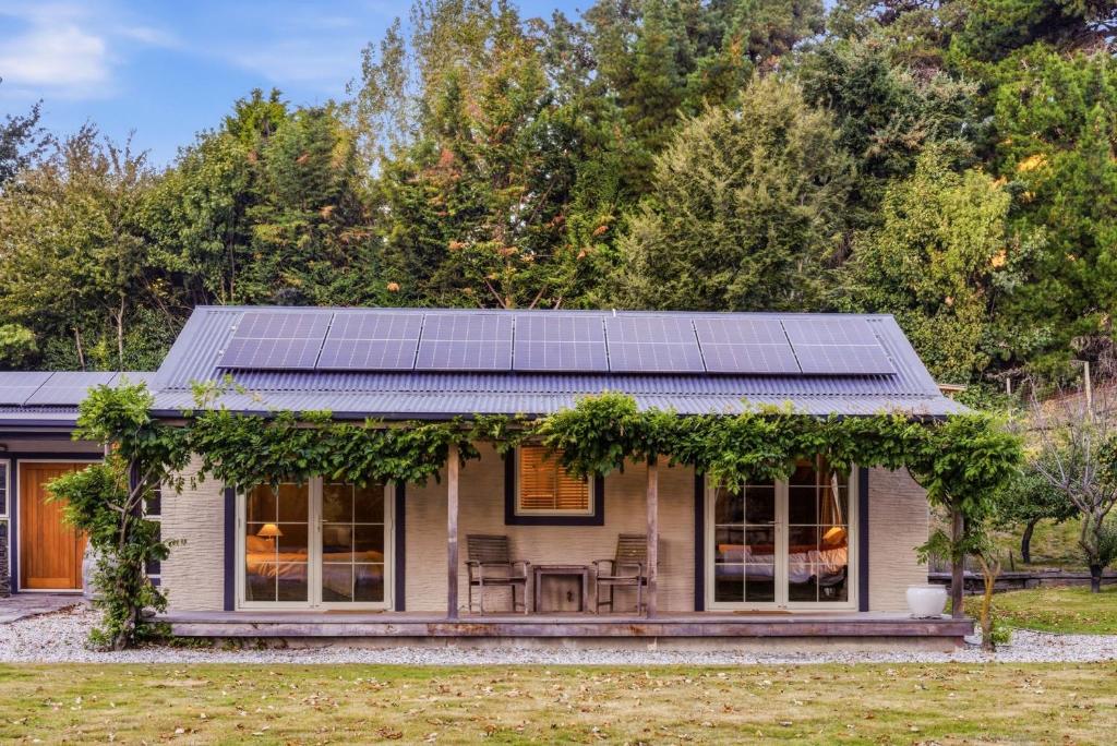 a small house with solar panels on the roof at Arrow Junction Cottage in Arrowtown