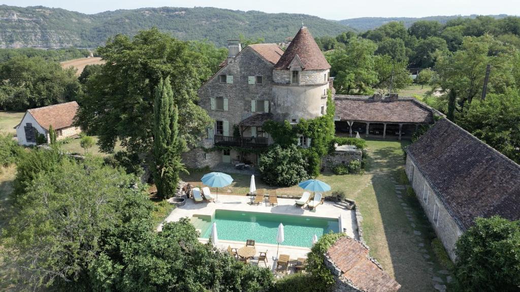 an estate with a swimming pool in front of a building at Mas De Garrigue - Chambres d'hôtes in Calvignac