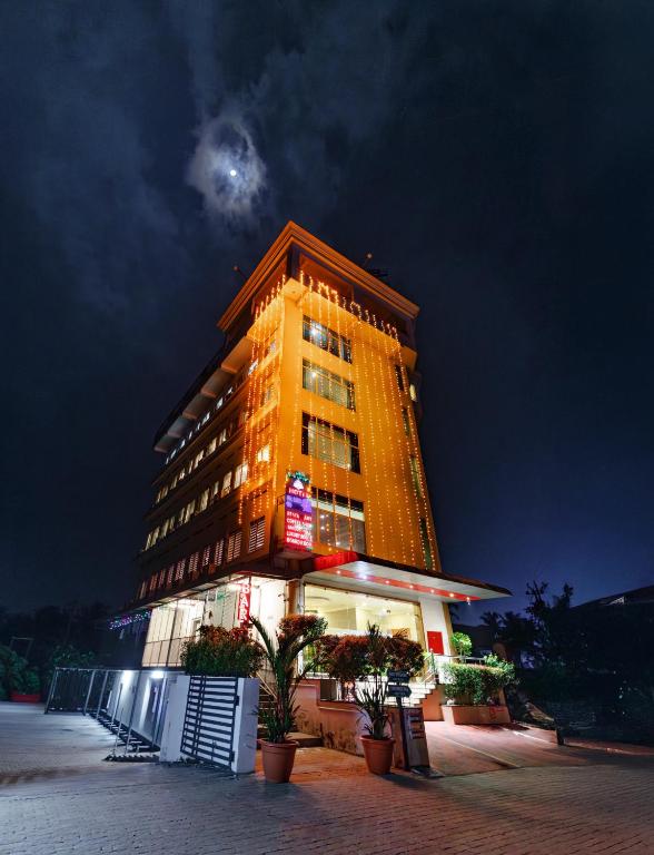 a building with the moon in the sky behind it at Hotel Lals Residency, Adoor in Adūr