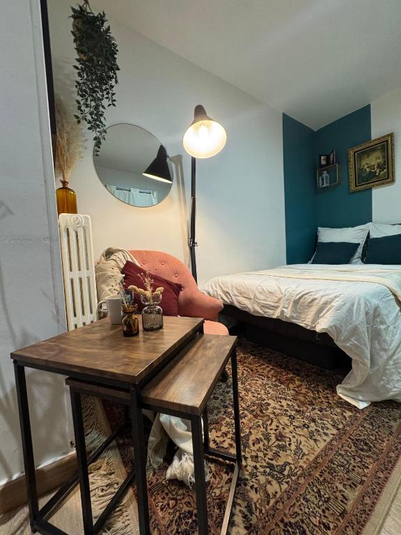 a bedroom with a bed and a table and a table sidx sidx sidx at Beau studio proche gare in Gagny