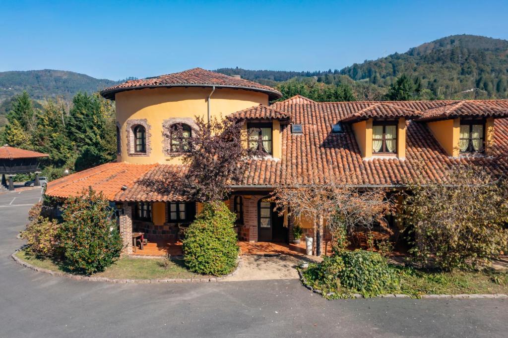 a large house with a tiled roof at Hotel El Bricial in Soto de Cangas