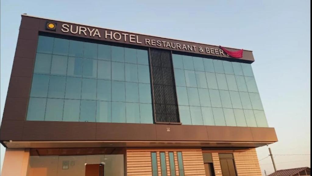 a building with a sign on top of it at Surya hotel in Gangāpur