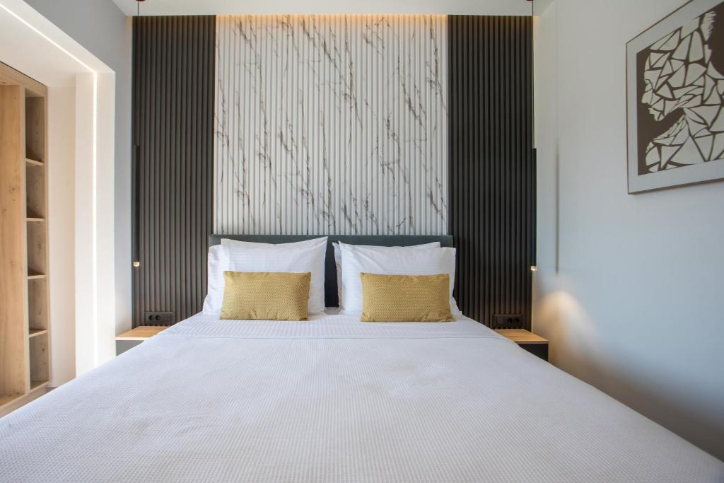 a bedroom with a large white bed with two pillows at Kallithea living in Koskinou