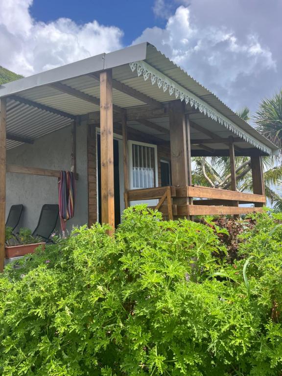 a house with a porch with a roof at Au pied du Piton Bellevue in Sainte-Rose