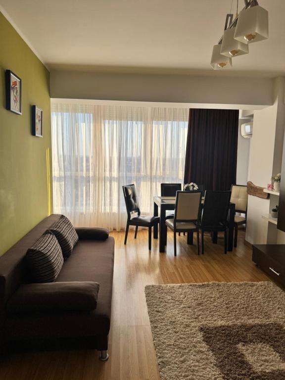 a living room with a couch and a table and chairs at Class Belvedere Apartments in Oradea