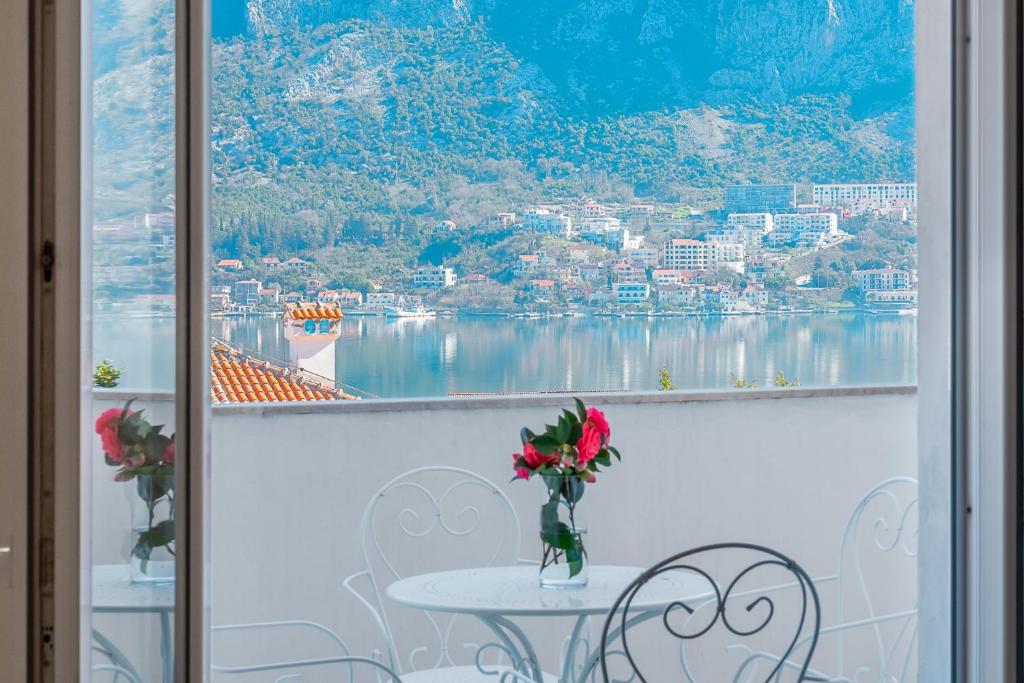 a table and chairs with a view of the water at Relaxing 2 bedroom apartment with Bay View and Parking in Prčanj