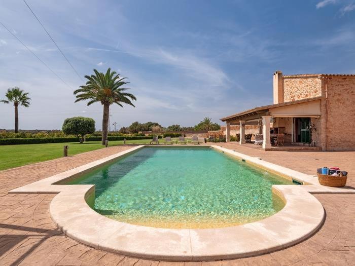 a large swimming pool in front of a house at S'hort d'en Bonet in Santanyi