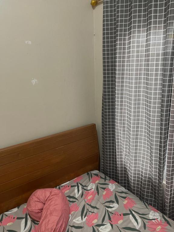 a bedroom with a bed and a curtain with flowers on it at Leon Mansion in Pulau Layang