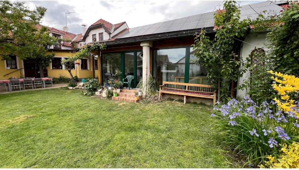 a house with a yard with a bench and flowers at Gästehaus Weinwurm in Obritz