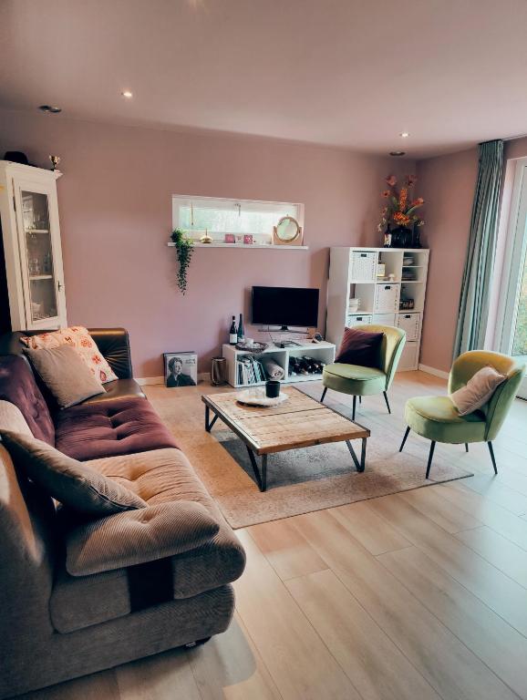 a living room with a couch and chairs and a table at B&B 't Herfter Erf in Zwolle