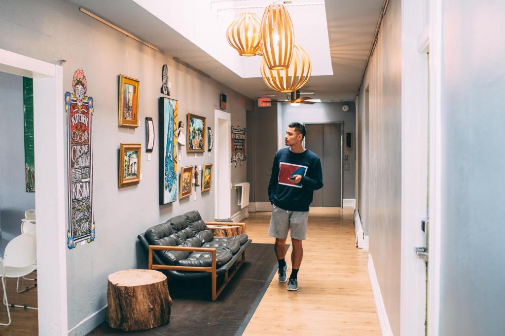 a person standing in a living room next to a wall at HI San Diego Downtown Hostel in San Diego