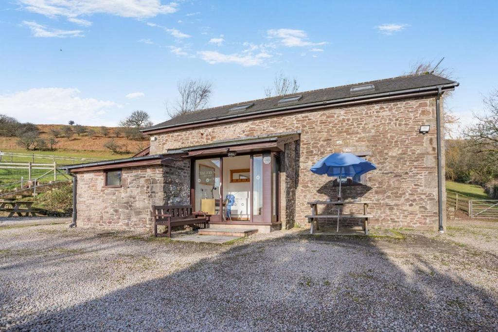 a stone cottage with a blue umbrella in front of it at 2 Bed in Risca oc-h35978 in Risca