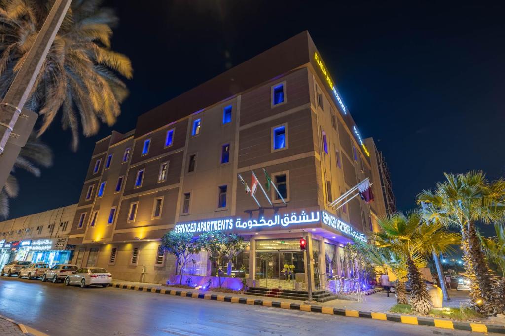 a large building with palm trees in front of it at Al Muhaidb Residence Al Malaz 1 - Economic in Riyadh