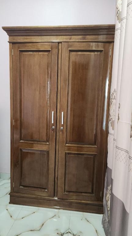 a wooden cabinet with two doors in a room at Velora Inn in Jakarta