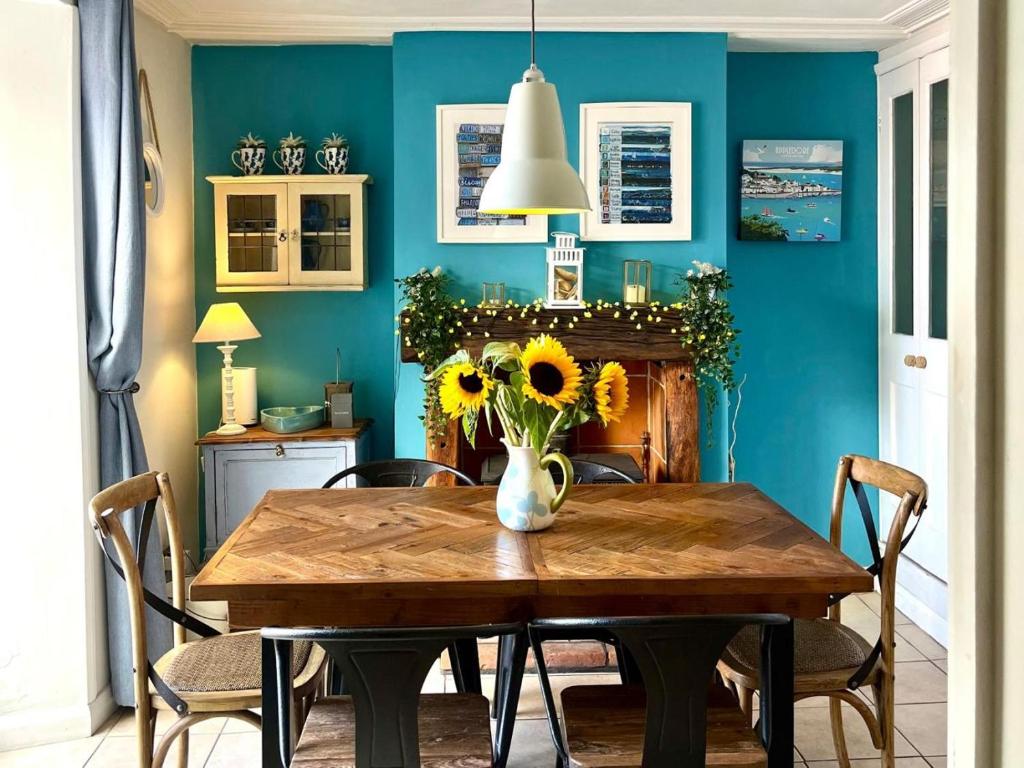 a dining room with a table with a vase of sunflowers at 3 Bed in Appledore oc-t28375 in Appledore