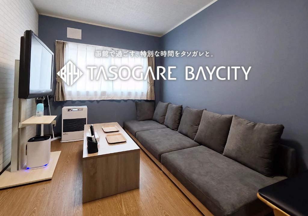 a living room with a couch and a tv at Tasogare Baycity in Hakodate