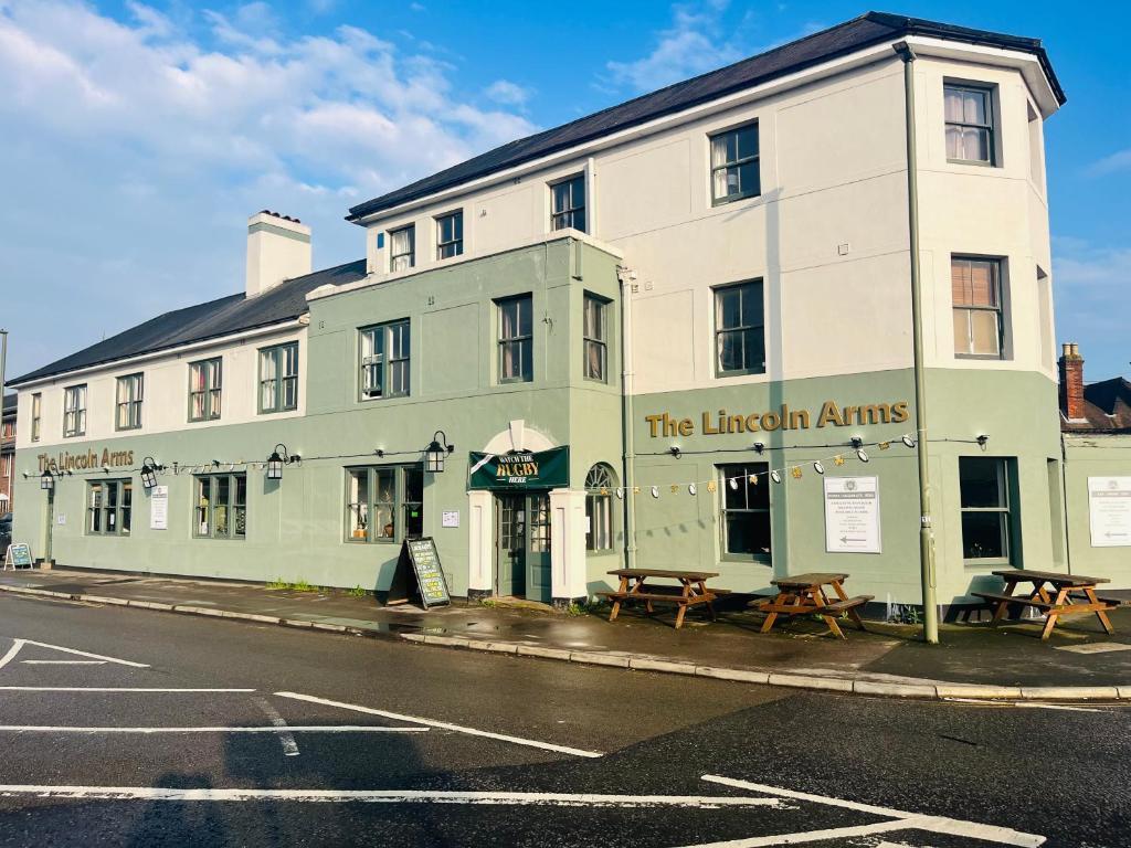 a large white building on the corner of a street at The Lincoln Arms Pub & Rooms in Dorking