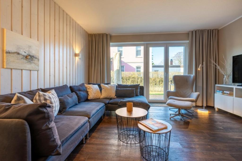 a living room with a blue couch and a table at Haus Tidehuus in Borkum