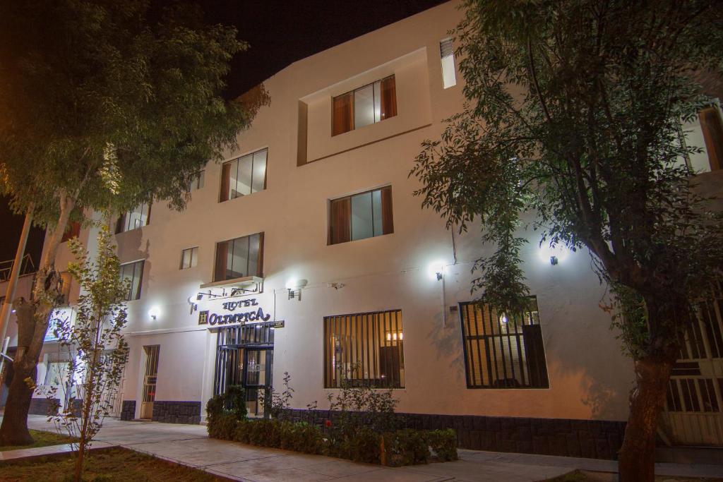 un gran edificio blanco con un cartel delante en Hotel Olímpica, en Arequipa