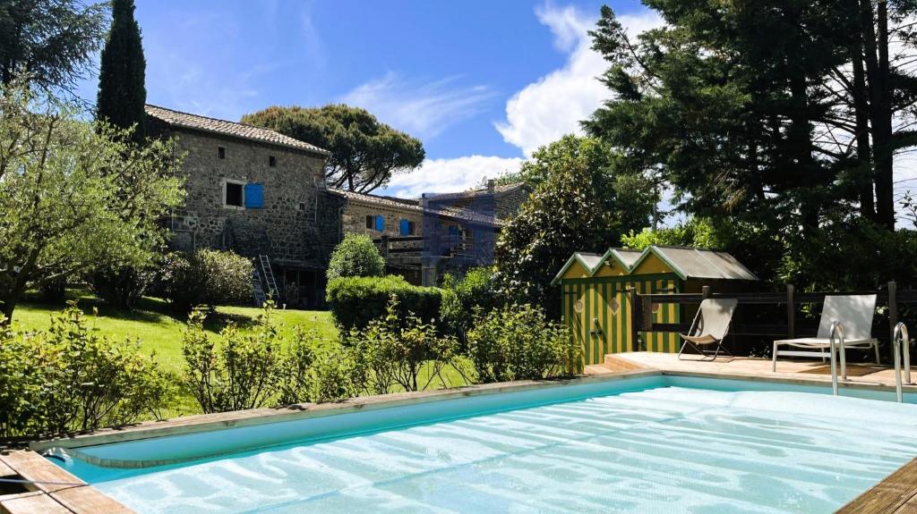 a swimming pool in the yard of a house at Le Petit Moras in Chomérac
